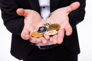 man holds different crypto coins in his hands on white 2 1